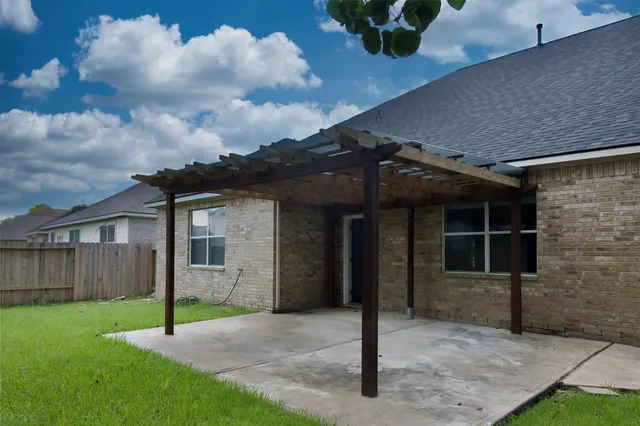 a view of a house with a yard and wooden fence