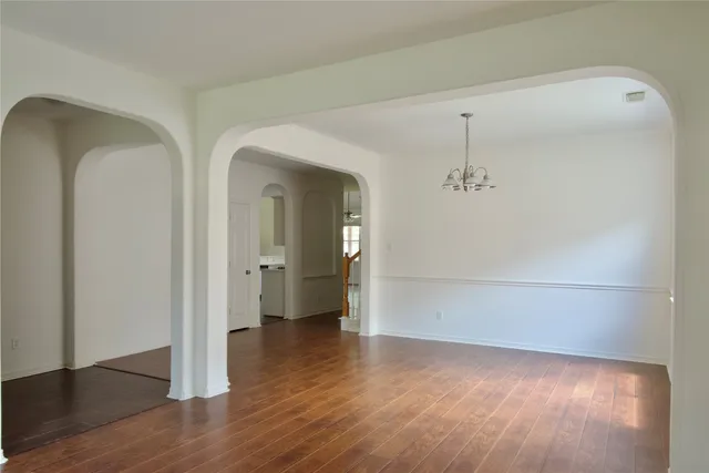 a view of a hallway with wooden floor and closet