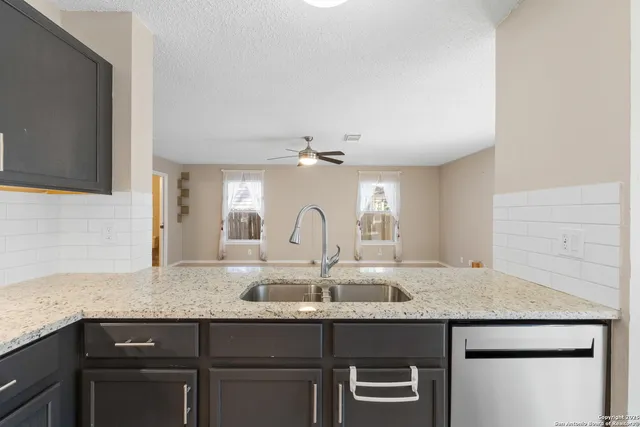 a kitchen with stainless steel appliances granite countertop a sink and stove top oven