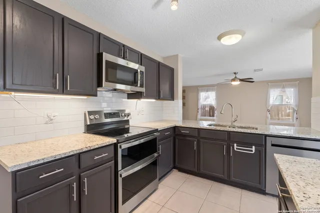 a kitchen with a granite countertop kitchen island a cabinets and stainless steel appliances