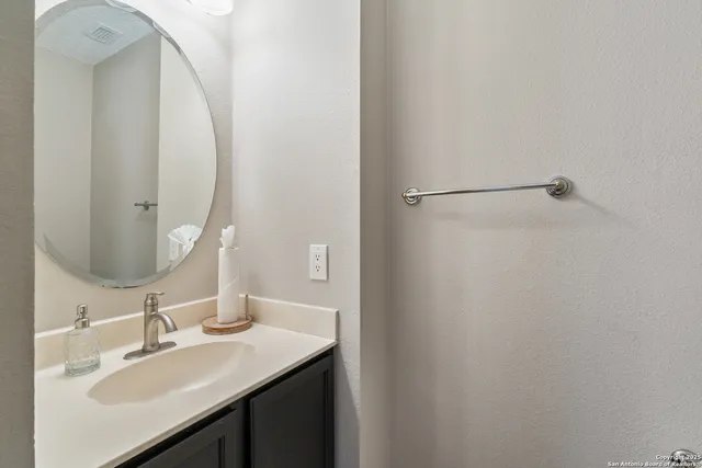 a bathroom with a sink vanity and a mirror