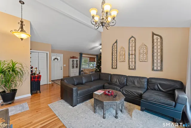 a living room with furniture chandelier and a table
