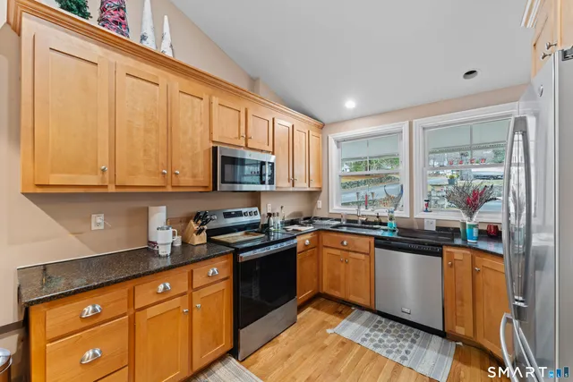 a kitchen with stainless steel appliances granite countertop a sink stove and microwave