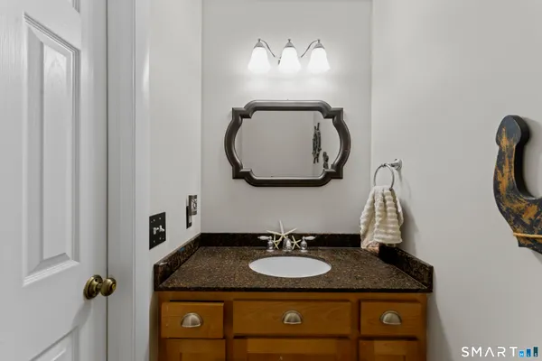 a bathroom with a granite countertop sink and a mirror