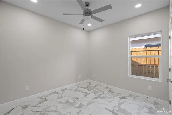 an empty room with a window and a fan