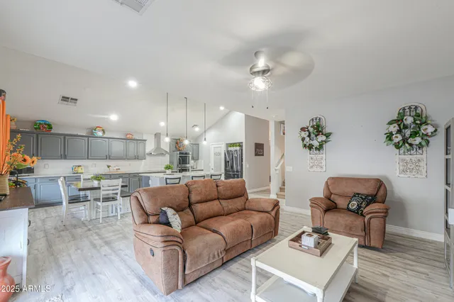 a spacious bedroom with a bed a dresser and a large window