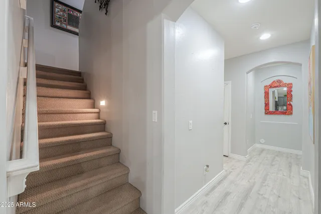 a spacious bedroom with a bed a couch and a flat tv screen on dresser