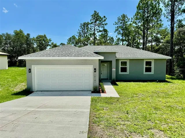 a view of a house with garage and yard