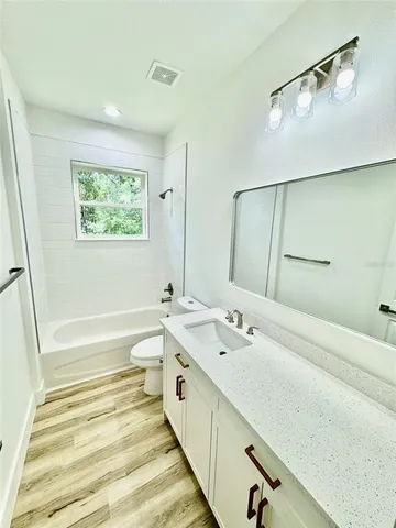 a spacious bathroom with a tub sink and a mirror