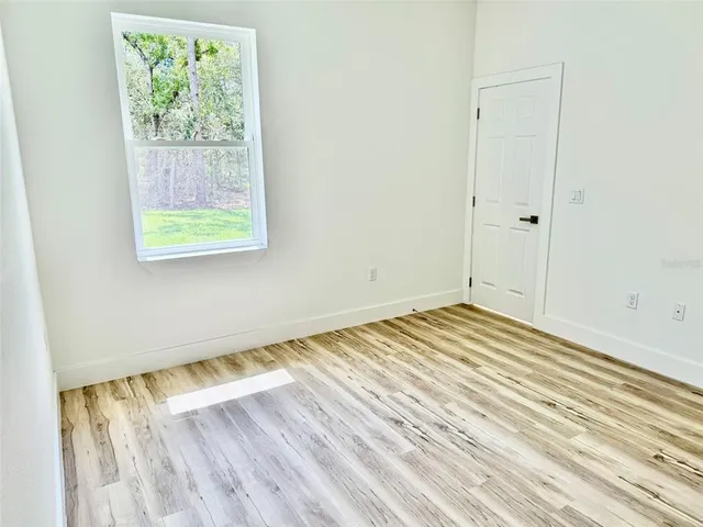 a view of a room with wooden floor and window