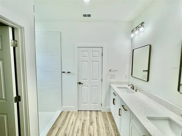 a spacious bathroom with a double vanity sink and mirror