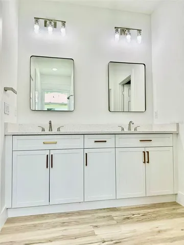 a bathroom with a sink mirror and vanity