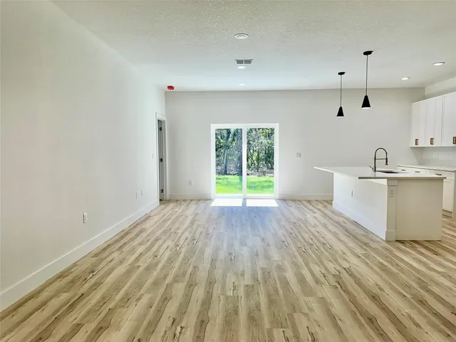 a view of a kitchen with wooden floor and a sink