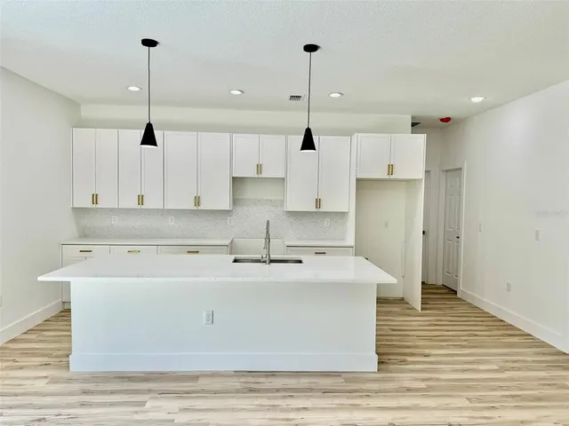 a kitchen with stainless steel appliances granite countertop a sink a stove and a refrigerator