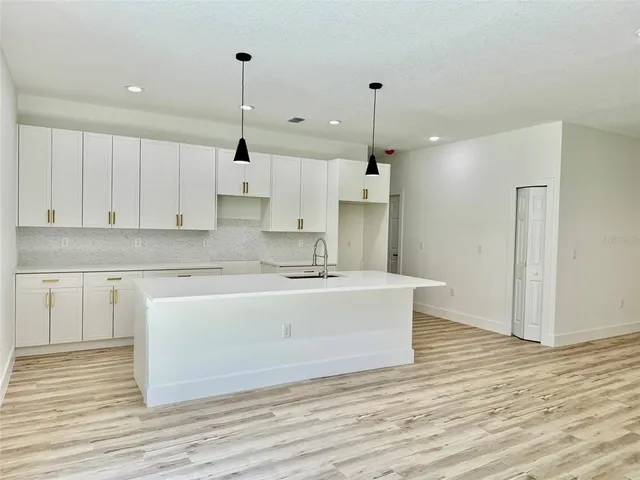 a large kitchen with granite countertop a white stove top oven and cabinets