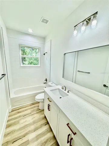 a spacious bathroom with a tub sink and mirror