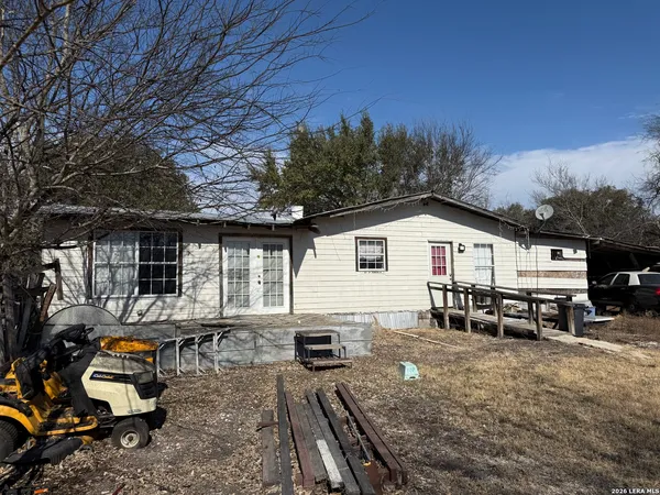 a view of a house with backyard and sitting area