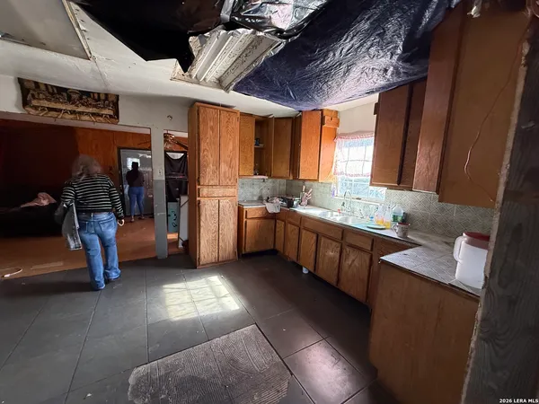 a large kitchen with stainless steel appliances granite countertop a sink and a counter top space