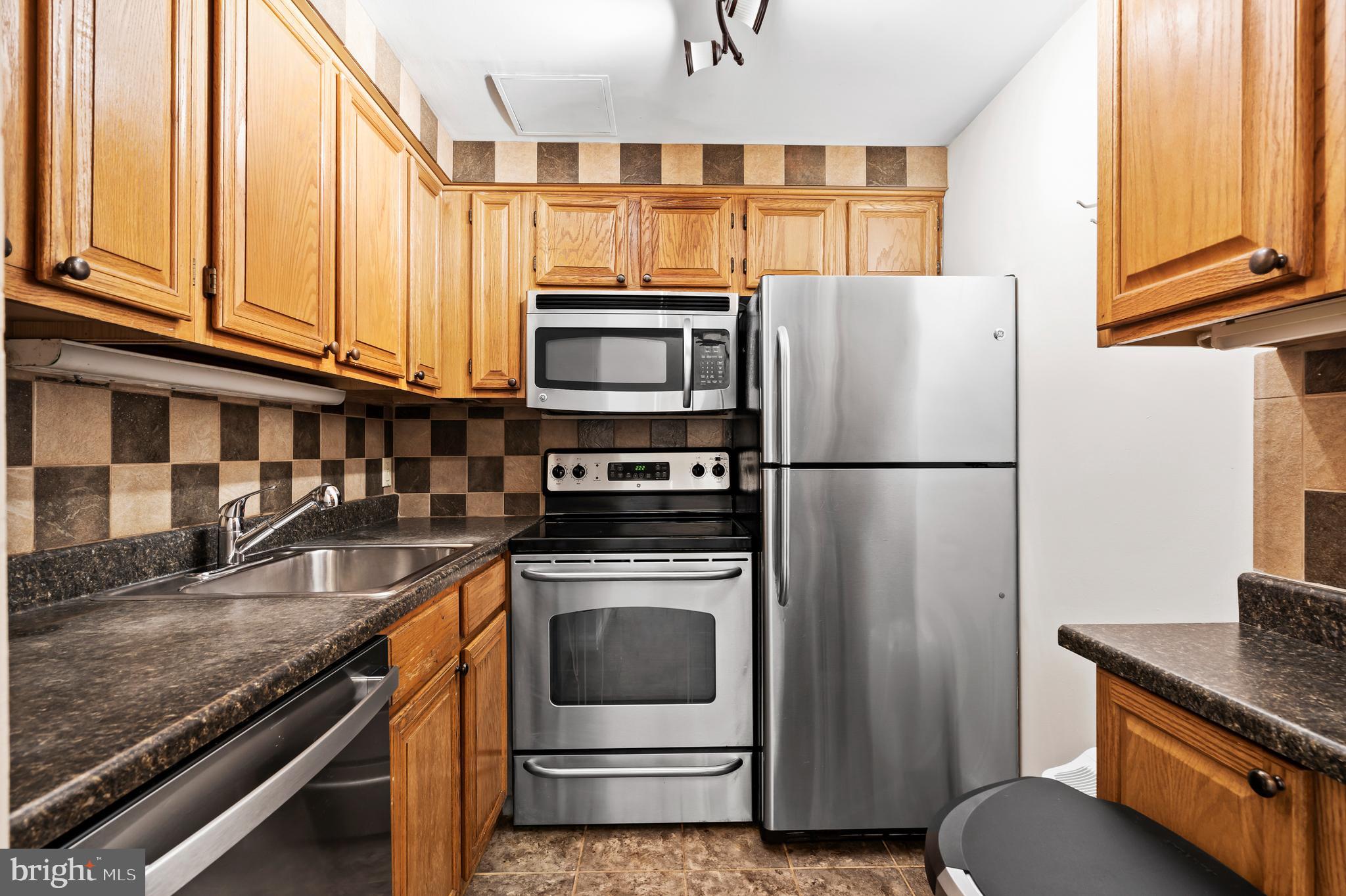 136 North Bread Street, Unit 130 Philadelphia, PA 19106 - Photo 8 of 31 a kitchen with stainless steel appliances granite countertop a refrigerator a stove and a sink