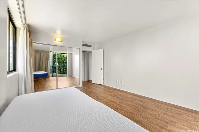 a bedroom with a bed and large window with outer view