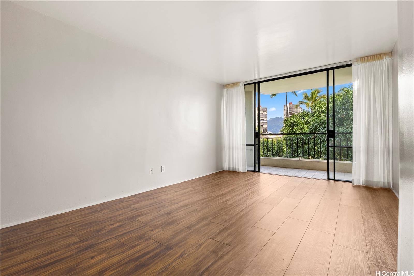 440 Seaside Avenue, Unit 404 Honolulu, HI 96815 - Photo 5 of 21 a view of an empty room with wooden floor and a window