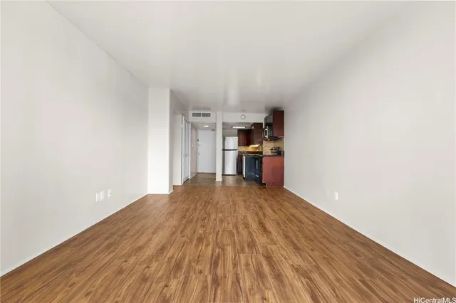 a view of empty room with wooden floor