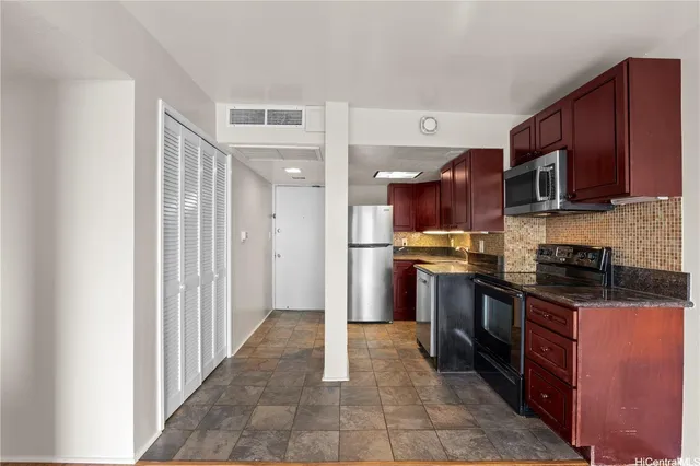 a kitchen with stainless steel appliances granite countertop a refrigerator and a stove top oven