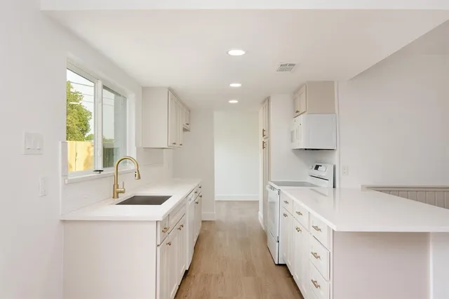 a kitchen with granite countertop a sink and cabinets