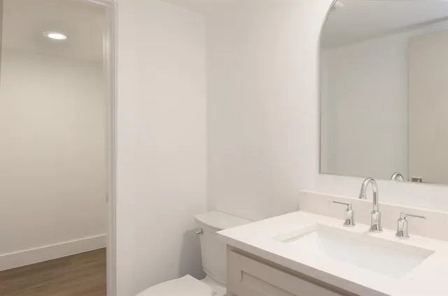 a bathroom with a sink a toilet and vanity