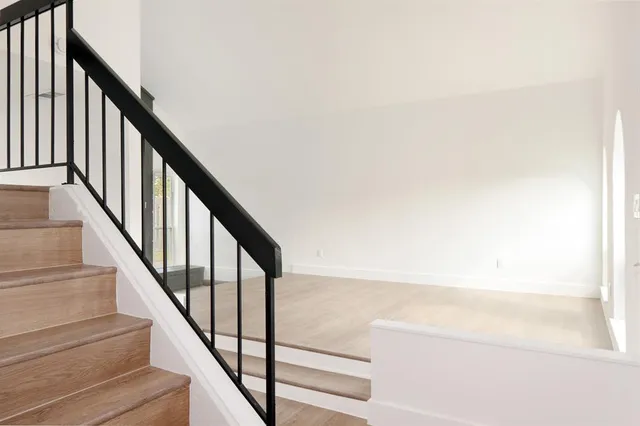 a view of staircase with wooden floor and white walls
