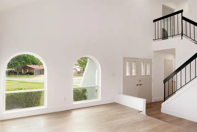 an empty room with windows and garden view