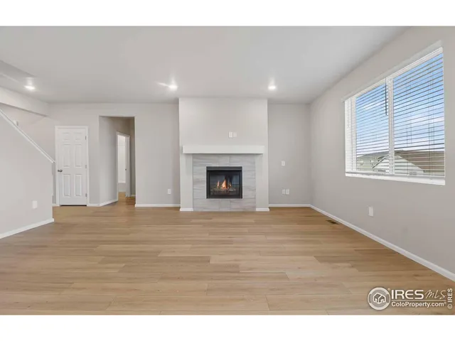 a view of empty room with wooden floor and fireplace