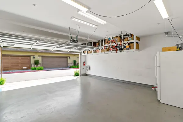 a view of kitchen with stainless steel appliances kitchen island granite countertop a sink and cabinets