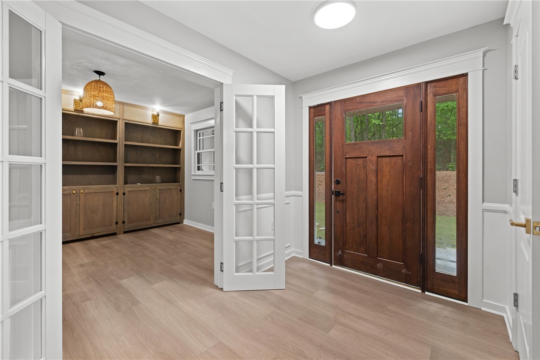 309 Woodland Way Clemson, SC 29631 - Photo 11 of 43 Enter through a rich wood door into a luminous space featuring built-in shelving and light wood flooring.