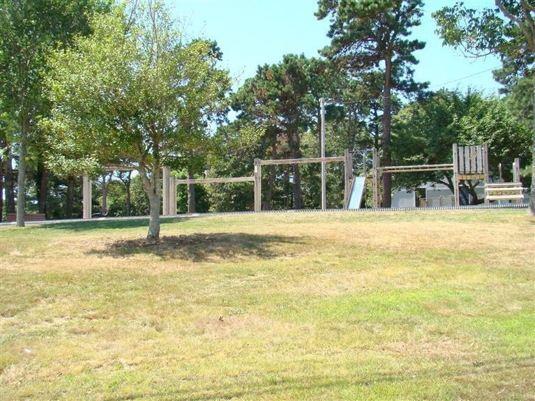80 County Road, Unit 3 North Falmouth, MA 02556 - Photo 8 of 17 a view of a swimming pool with a lawn chairs and large trees