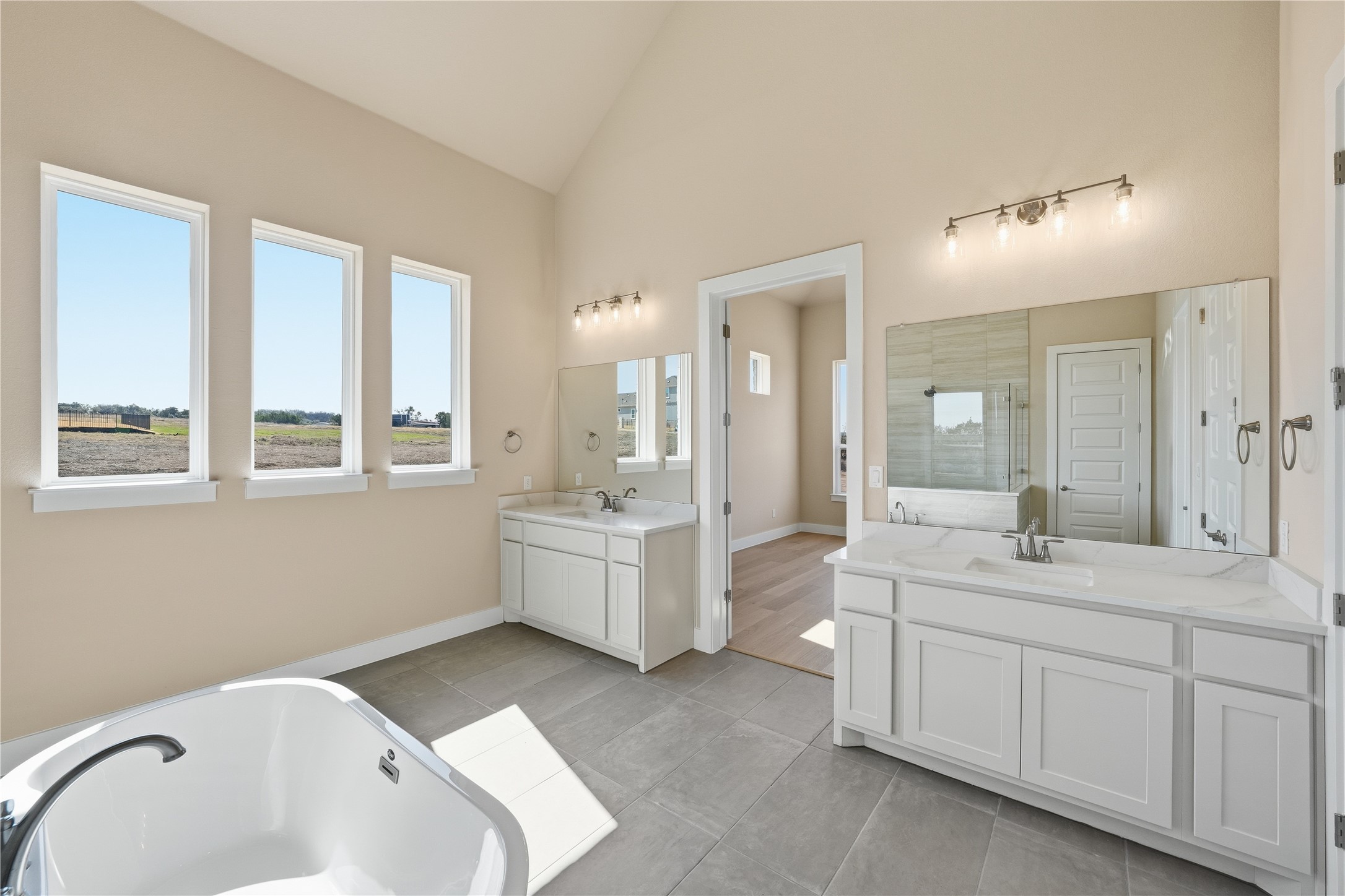 1209 Doelling Drive Georgetown, TX 78633 - Photo 14 of 31 Full bathroom with a stall shower, a freestanding bath, two vanities, lofted ceiling, and light tile patterned floors