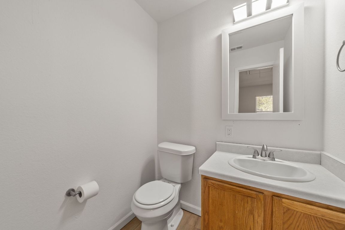 1804 Singleton Avenue Austin, TX 78702 - Photo 30 of 36 a bathroom with a granite countertop sink a toilet and a mirror