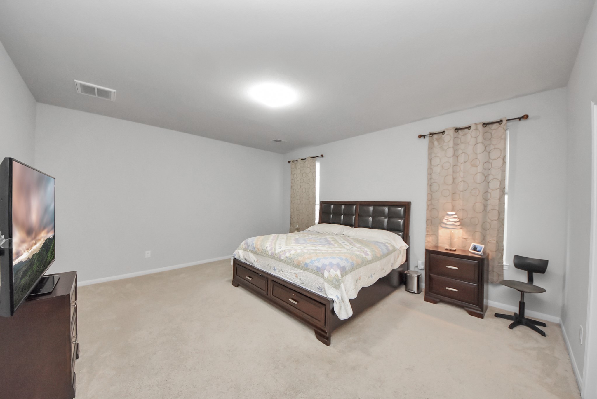 4239 Wyanngate Drive Spring, TX 77373 - Photo 18 of 36 a spacious bedroom with a bed and a flat screen tv