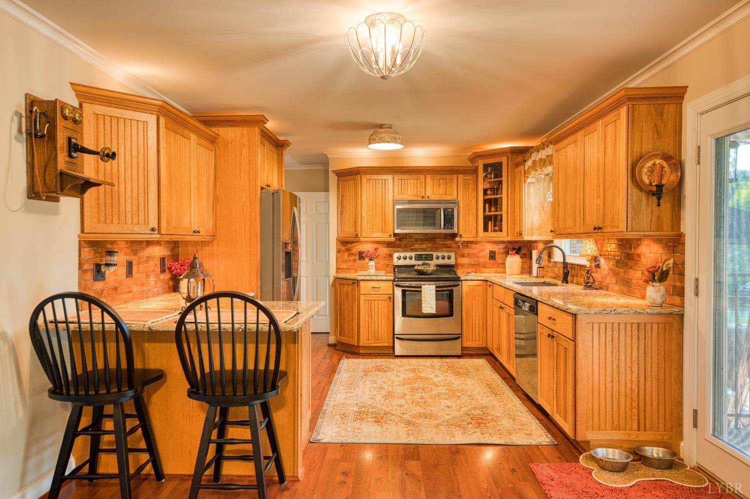 2287 Johnson Creek Road Evington, VA 24550 - Photo 15 of 70 a kitchen with stainless steel appliances kitchen island granite countertop a refrigerator a stove a sink dishwasher with a dining table and chairs