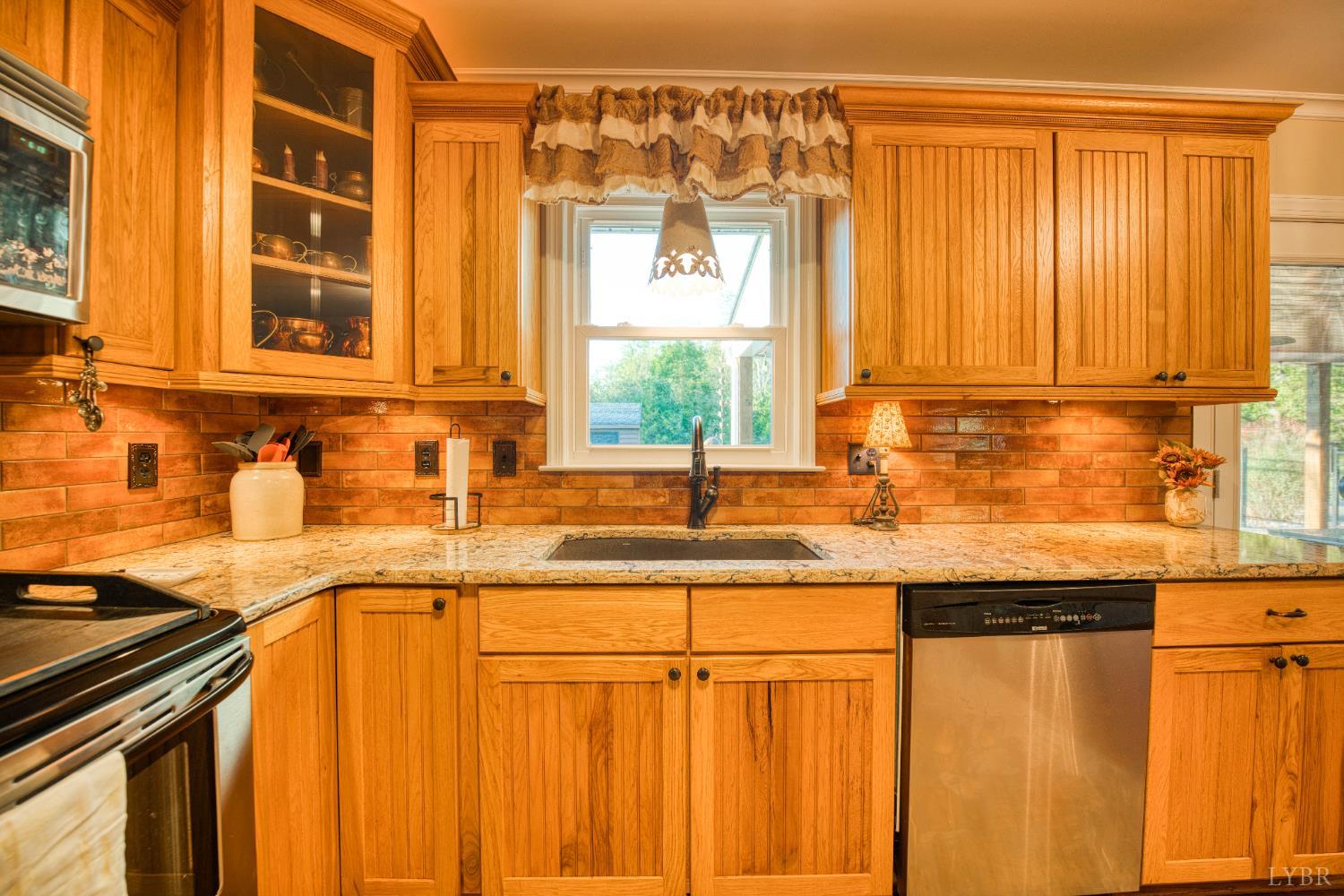 2287 Johnson Creek Road Evington, VA 24550 - Photo 17 of 70 a kitchen with stainless steel appliances granite countertop a sink window and cabinets