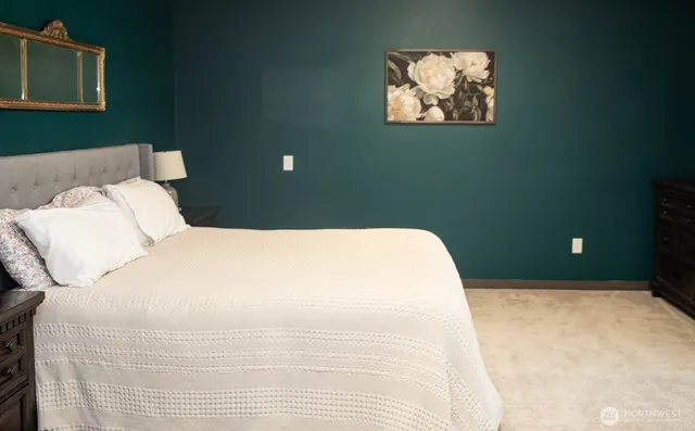 a bedroom with a bed and a painting on the wall