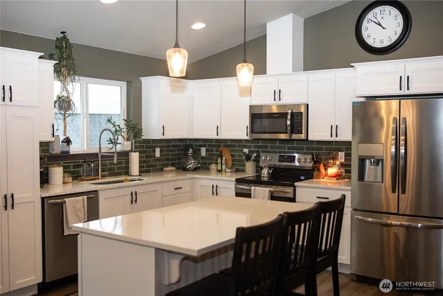 a kitchen with stainless steel appliances a stove a refrigerator a sink and a refrigerator