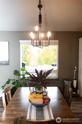 a view of a dining room with furniture a potted plant and wooden floor