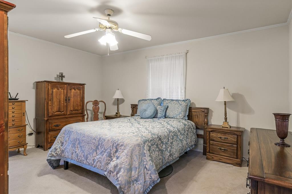 114 Granada Square Canton, TX 75103 - Photo 11 of 23 a bedroom with bed a lamp and a flat tv screen on the dresser