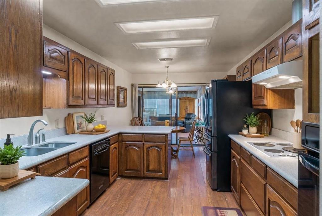 114 Granada Square Canton, TX 75103 - Photo 10 of 23 a kitchen with stainless steel appliances granite countertop a sink a stove and a wooden floors