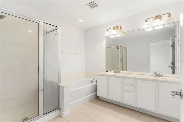 a bathroom with a double vanity sink mirror and bathtub