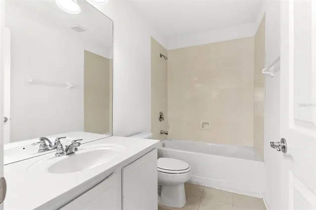 a bathroom with a bathtub shower sink vanity mirror and toilet