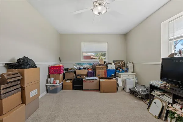a living room with furniture a flat screen tv and a window