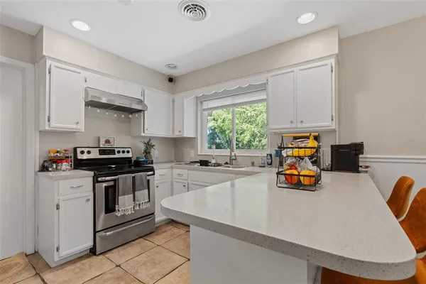 a kitchen with a stove a sink and a granite counter tops