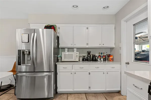 a kitchen with white cabinets and white appliances